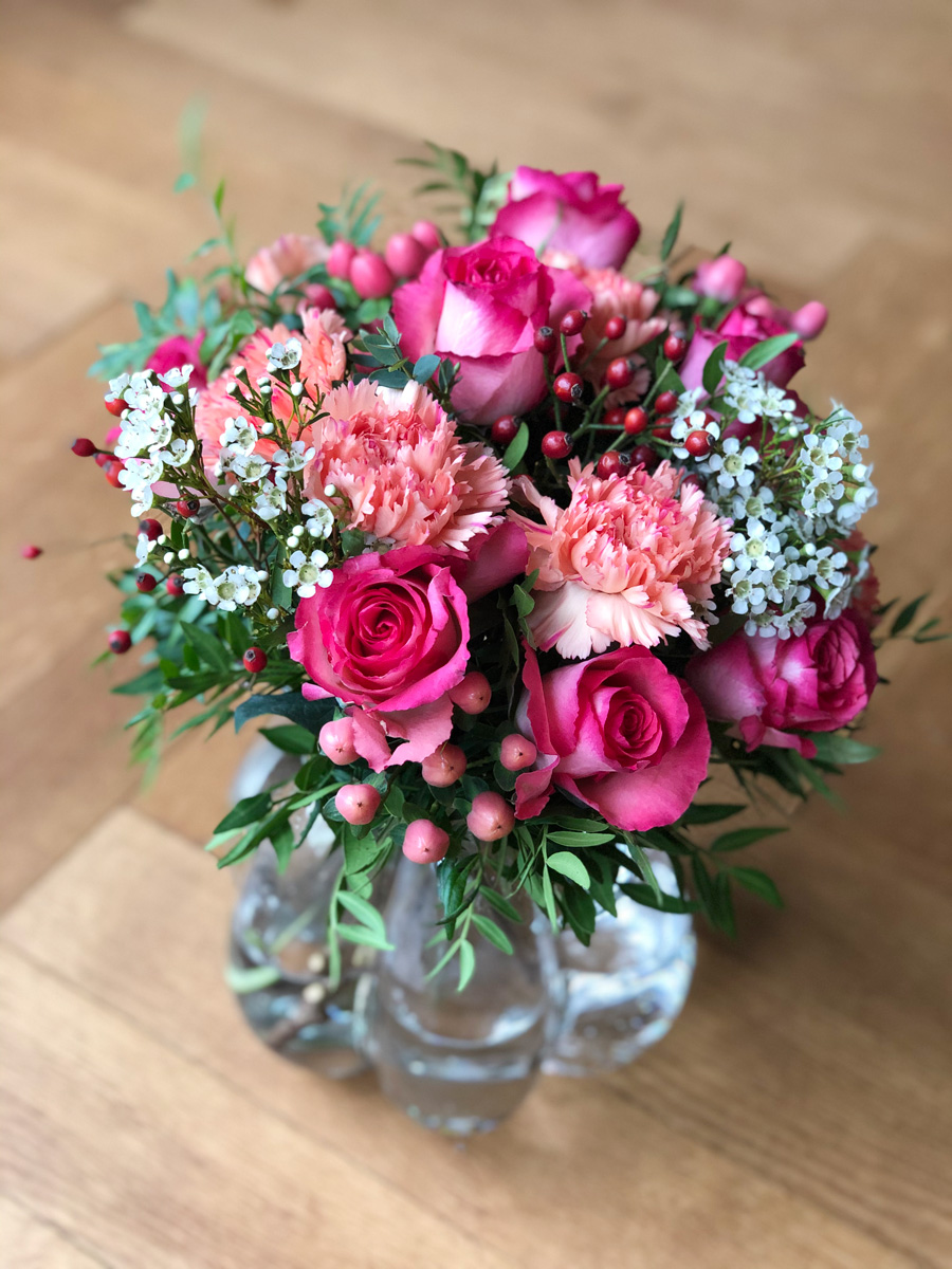 Blumenstrauss in der Hergiswiler-Glasvase mit Rosen, Nelken, Wachsblumen und Hagebutten